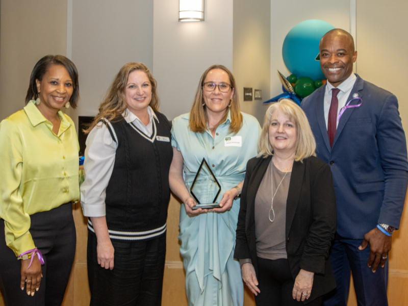 Image shows three people receiving an award