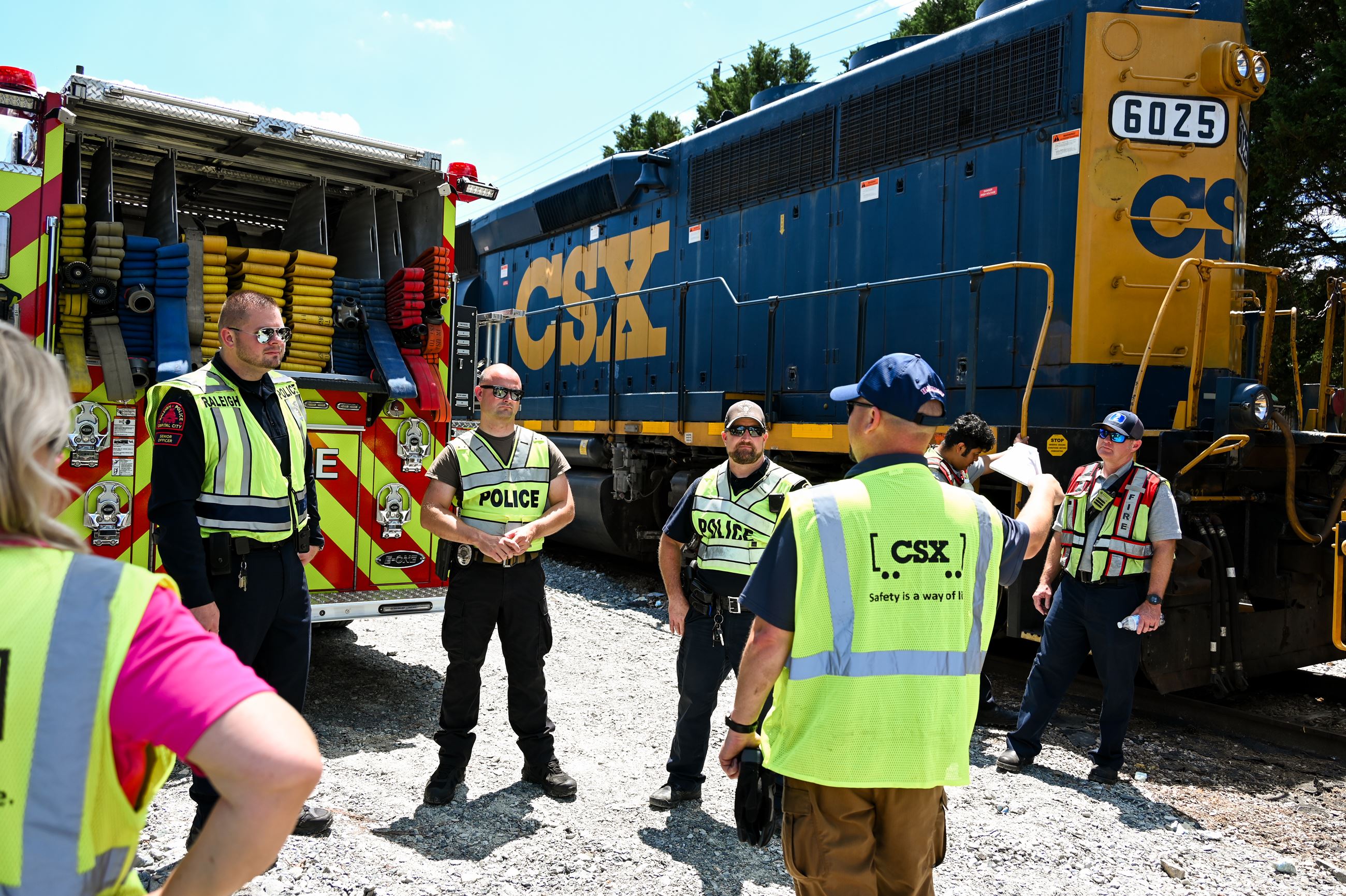 Police officers listening to an instructor outside a CSX rail car
